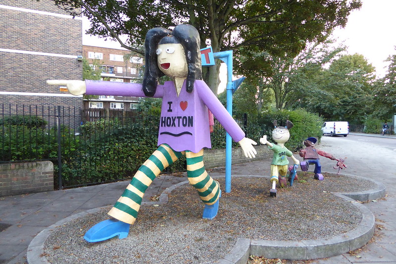 Sculpture from 2001 of a family walking, the front one with a badge that says 