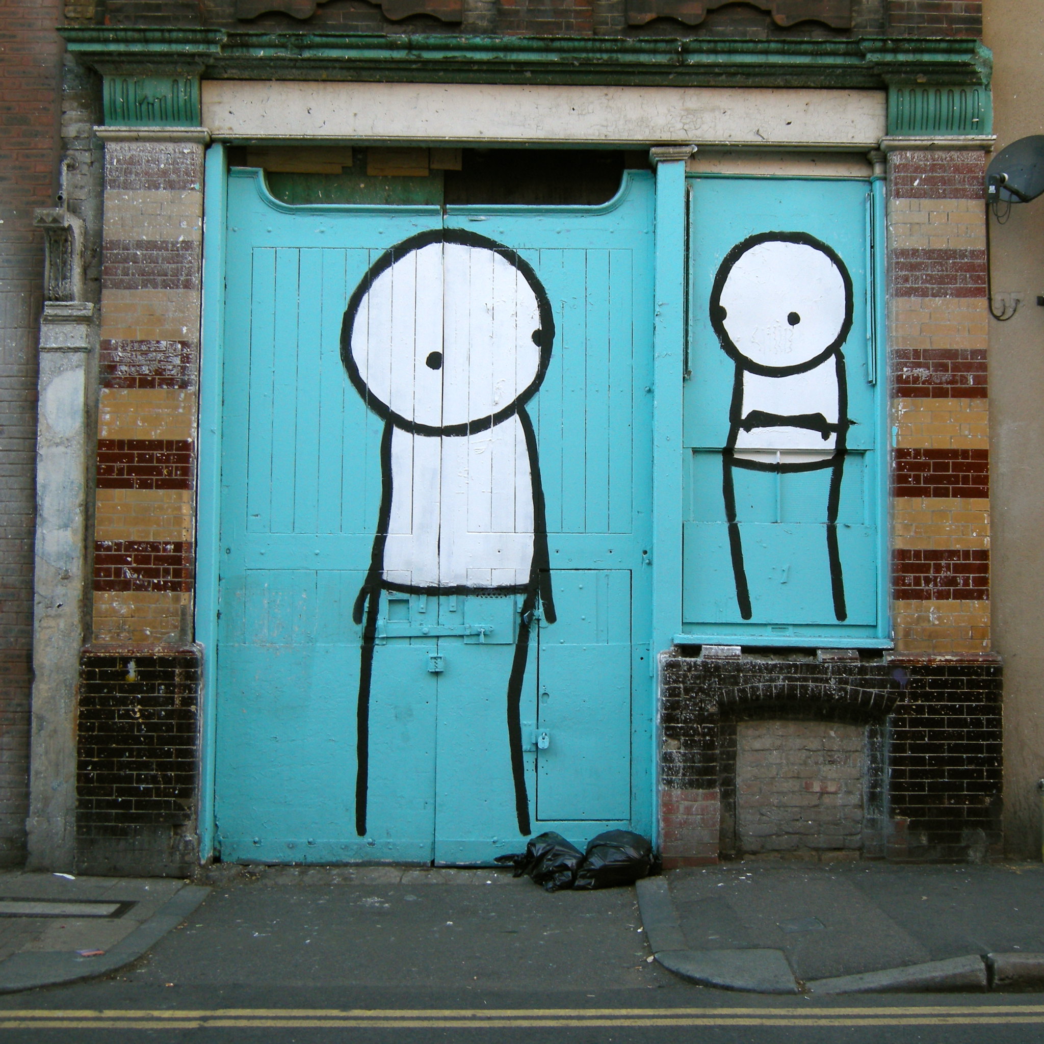 Abandoned building in Hoxton with cyan grafiti. 