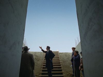 A screenshot from the Brutalist, 'community spaces' imprinted on top.